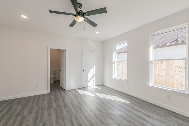 unfurnished bedroom featuring recessed lighting, wood finished floors, and baseboards