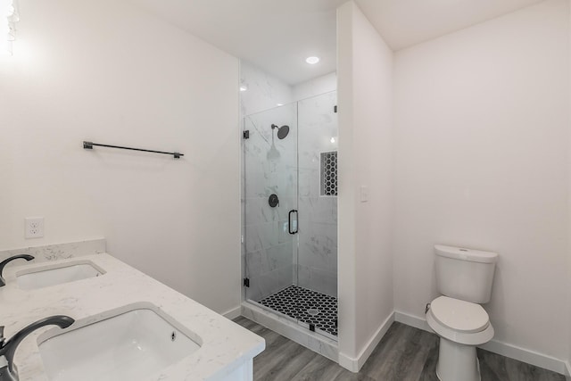 bathroom with a sink, a shower stall, toilet, and wood finished floors