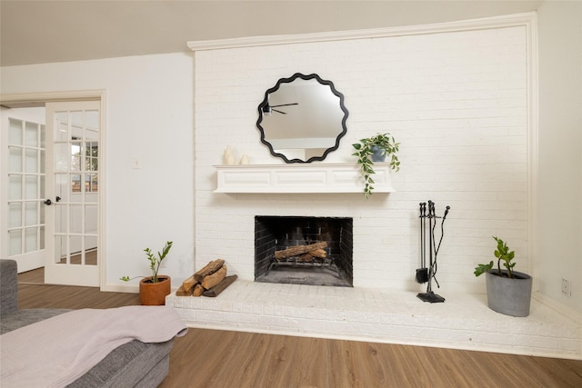 details featuring a brick fireplace and wood finished floors