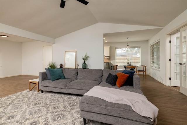 living area featuring vaulted ceiling, ceiling fan, wood finished floors, and baseboards