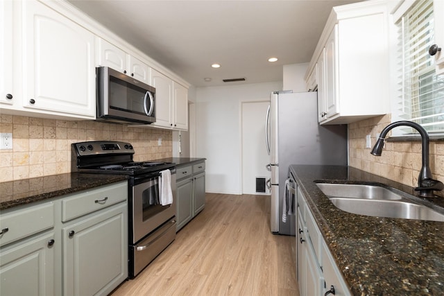 kitchen with light wood-type flooring, white cabinetry, appliances with stainless steel finishes, and a sink