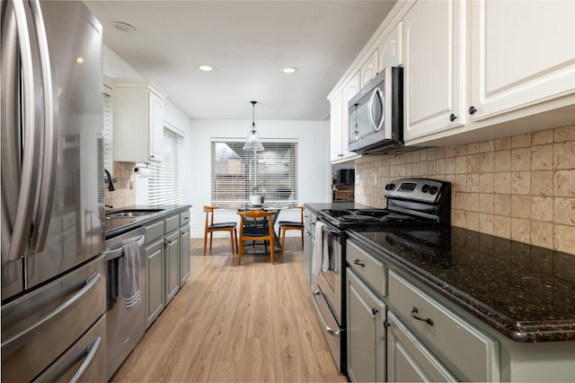 kitchen featuring light wood-style flooring, white cabinetry, stainless steel appliances, and a sink