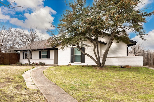 ranch-style house with brick siding, a front yard, and fence