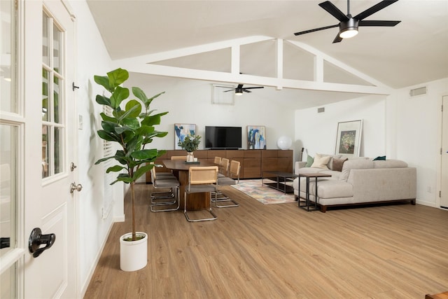 living area featuring ceiling fan, high vaulted ceiling, light wood finished floors, and visible vents