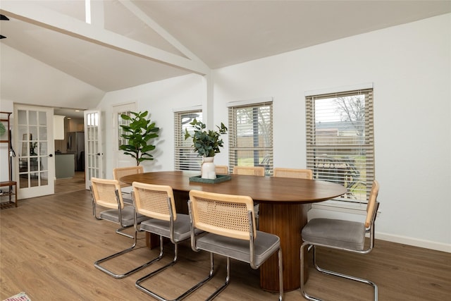 dining room featuring lofted ceiling, french doors, baseboards, and light wood finished floors