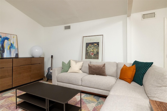 living area featuring lofted ceiling and visible vents