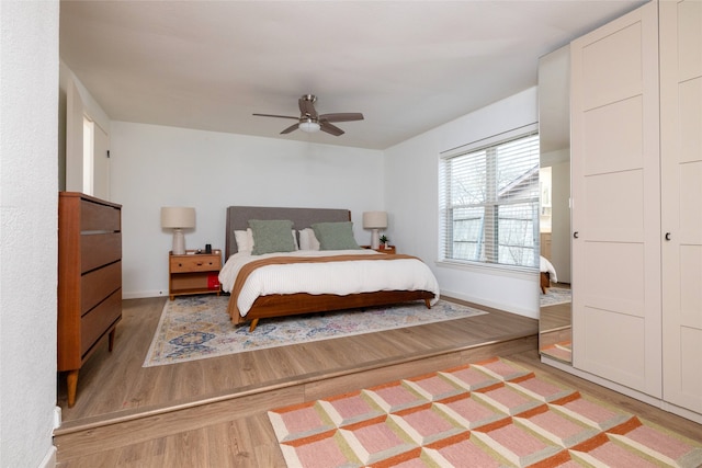 bedroom featuring baseboards, a ceiling fan, and light wood-style floors