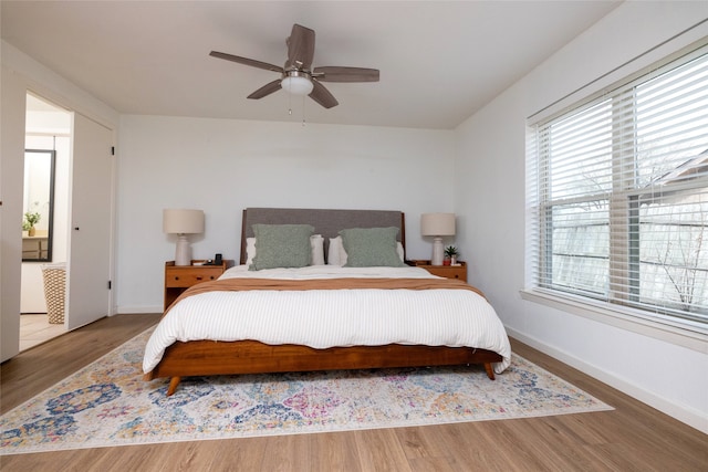 bedroom featuring a ceiling fan, baseboards, and wood finished floors