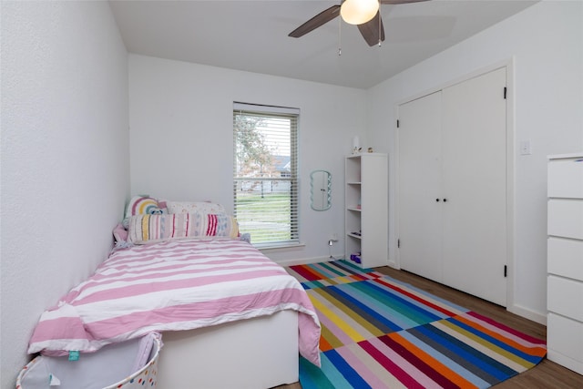 bedroom featuring a ceiling fan, a closet, baseboards, and wood finished floors