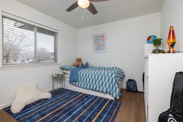 bedroom featuring ceiling fan, baseboards, and wood finished floors