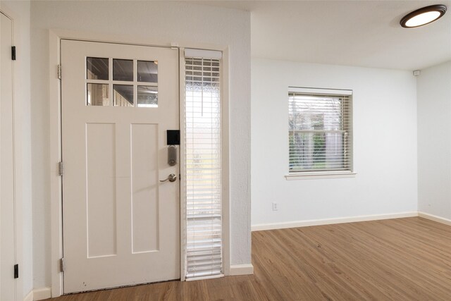 foyer featuring wood finished floors and baseboards