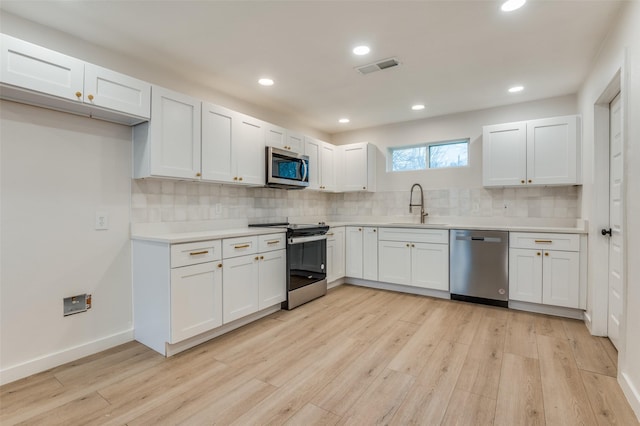 kitchen featuring light countertops, visible vents, appliances with stainless steel finishes, a sink, and light wood-type flooring