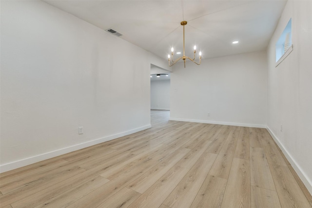 unfurnished dining area with light wood finished floors, visible vents, baseboards, and a notable chandelier