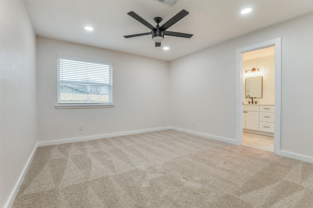 unfurnished bedroom with recessed lighting, baseboards, a sink, and light colored carpet