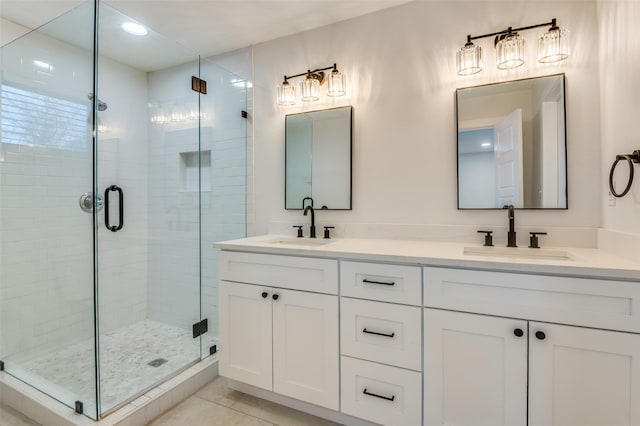 bathroom with a sink, a shower stall, and double vanity