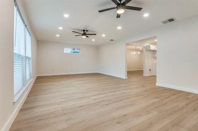 empty room featuring recessed lighting, visible vents, light wood finished floors, and ceiling fan with notable chandelier