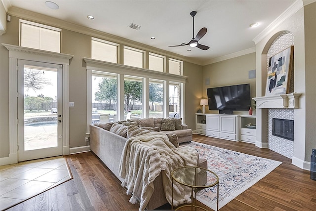 living area featuring ornamental molding, a wealth of natural light, and visible vents