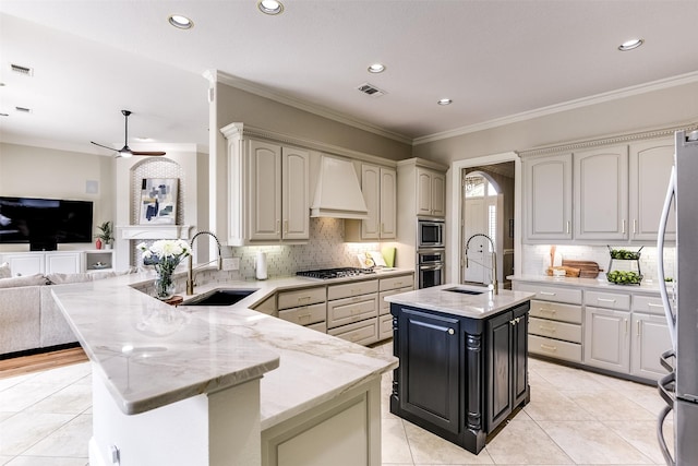 kitchen with visible vents, open floor plan, a peninsula, custom exhaust hood, and a sink