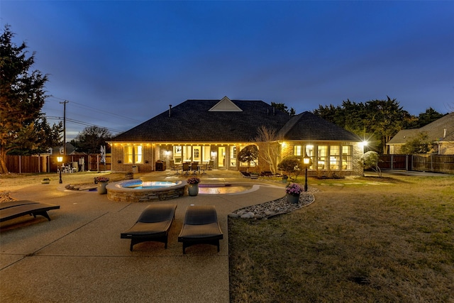 rear view of house with a fenced in pool, a yard, a patio area, an in ground hot tub, and a fenced backyard