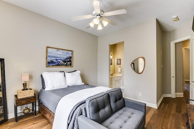 bedroom with ensuite bathroom, ceiling fan, baseboards, and wood finished floors