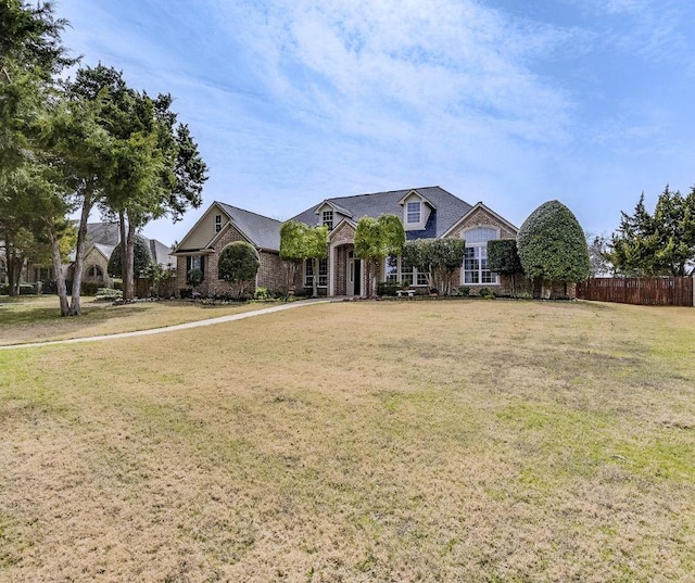 view of front of house with a front yard and fence