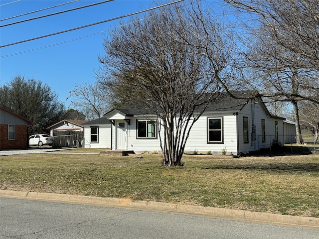 view of front of home featuring fence and a front lawn