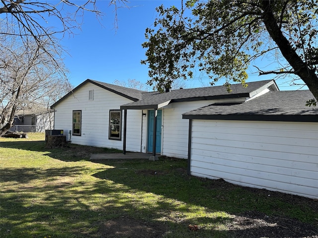 view of front of house with a shingled roof and a front lawn