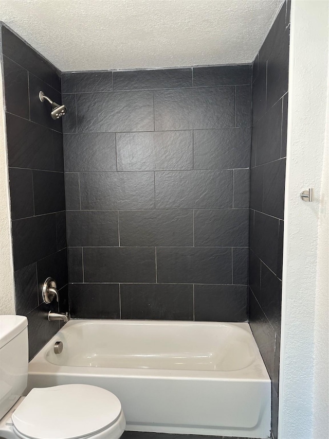 full bathroom with a textured ceiling, washtub / shower combination, and toilet