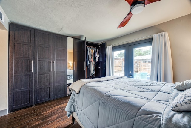 bedroom featuring french doors, dark wood finished floors, a closet, ceiling fan, and a textured ceiling