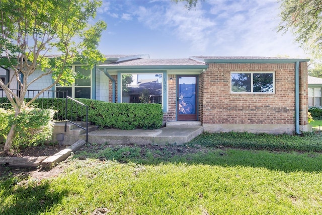 view of front of property featuring a front yard and brick siding