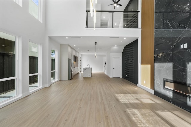 living area featuring plenty of natural light, a premium fireplace, and light wood-style flooring