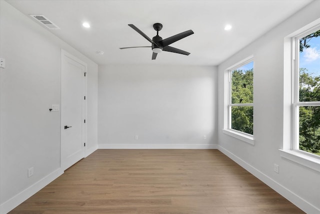 spare room featuring recessed lighting, visible vents, baseboards, and wood finished floors