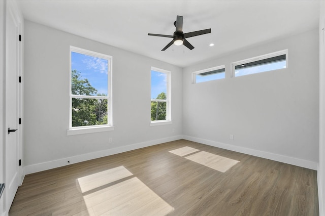 empty room featuring recessed lighting, wood finished floors, a ceiling fan, and baseboards