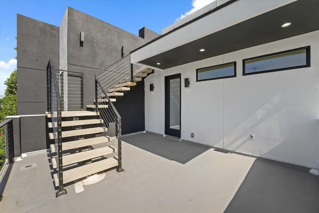 doorway to property featuring a patio area and stucco siding