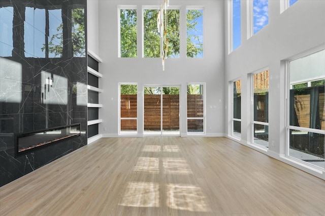 unfurnished living room featuring a fireplace, wood finished floors, and baseboards