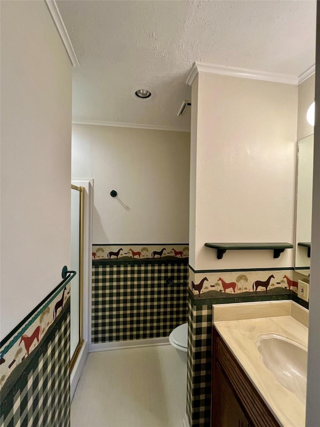 full bathroom featuring toilet, vanity, ornamental molding, a textured ceiling, and a shower