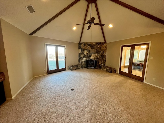 unfurnished living room featuring beam ceiling, french doors, a fireplace, carpet flooring, and baseboards