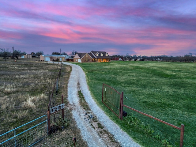 view of road with a rural view, driveway, and a gated entry