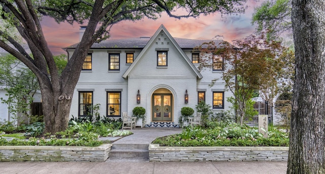 view of front facade featuring french doors and brick siding