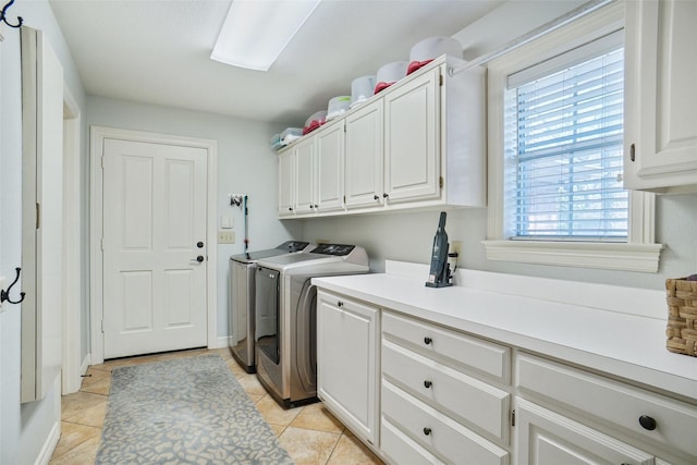 washroom with light tile patterned floors, cabinet space, and washer and dryer