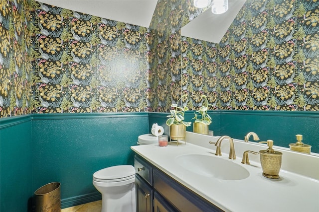 bathroom with toilet, wainscoting, and vanity