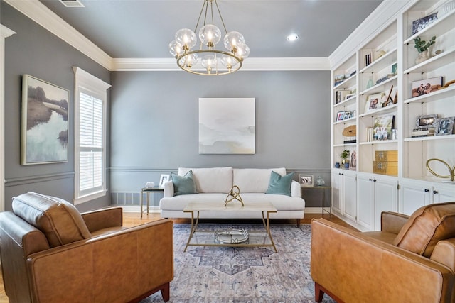 living area featuring built in features, a notable chandelier, crown molding, and baseboards