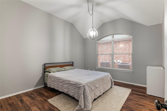 bedroom with vaulted ceiling, dark wood-type flooring, and baseboards