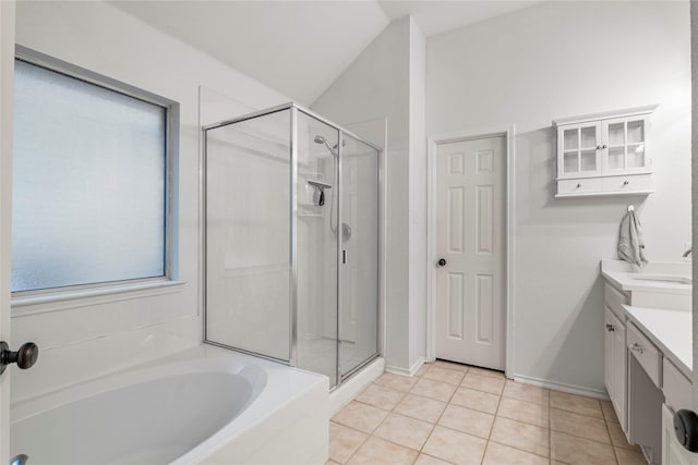 bathroom featuring a stall shower, tile patterned flooring, a garden tub, and vanity