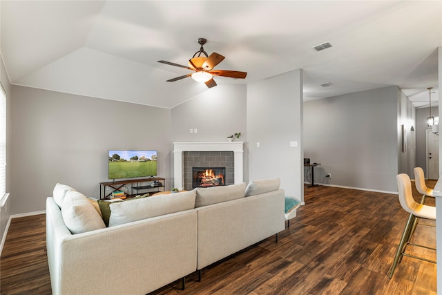 living area featuring dark wood-type flooring, a fireplace, and vaulted ceiling