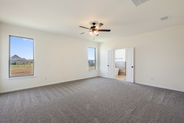 unfurnished room with carpet, visible vents, ceiling fan, and baseboards