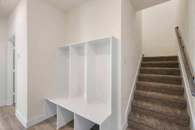 mudroom featuring light wood finished floors and baseboards