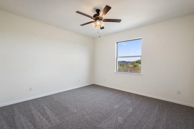 empty room with baseboards, dark colored carpet, and a ceiling fan