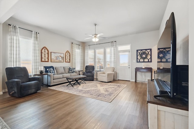 living area with a ceiling fan and wood finished floors