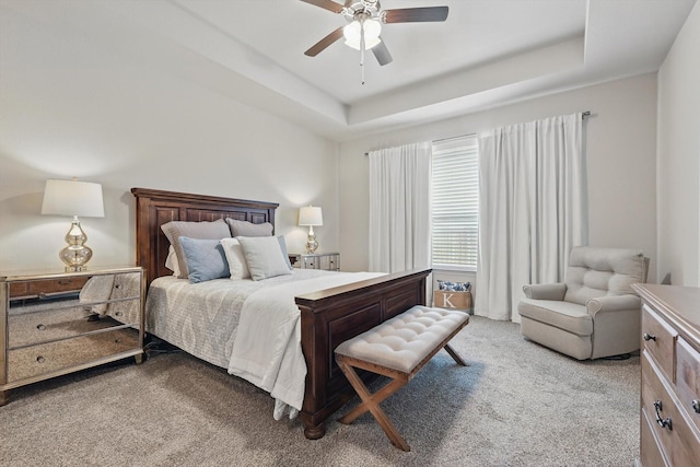 bedroom with carpet floors, a tray ceiling, and ceiling fan